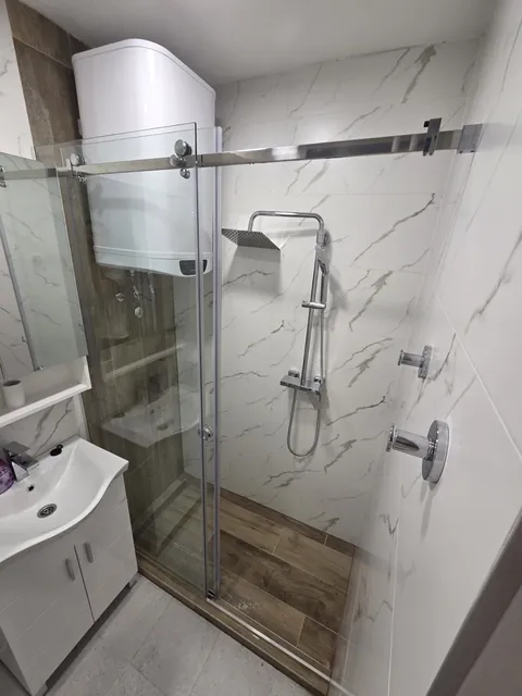 Klizna ravna tuš kabina po mjeri u Tuzli sa sjajnim okovom i prozirnim staklom, pored lavabo i bojler